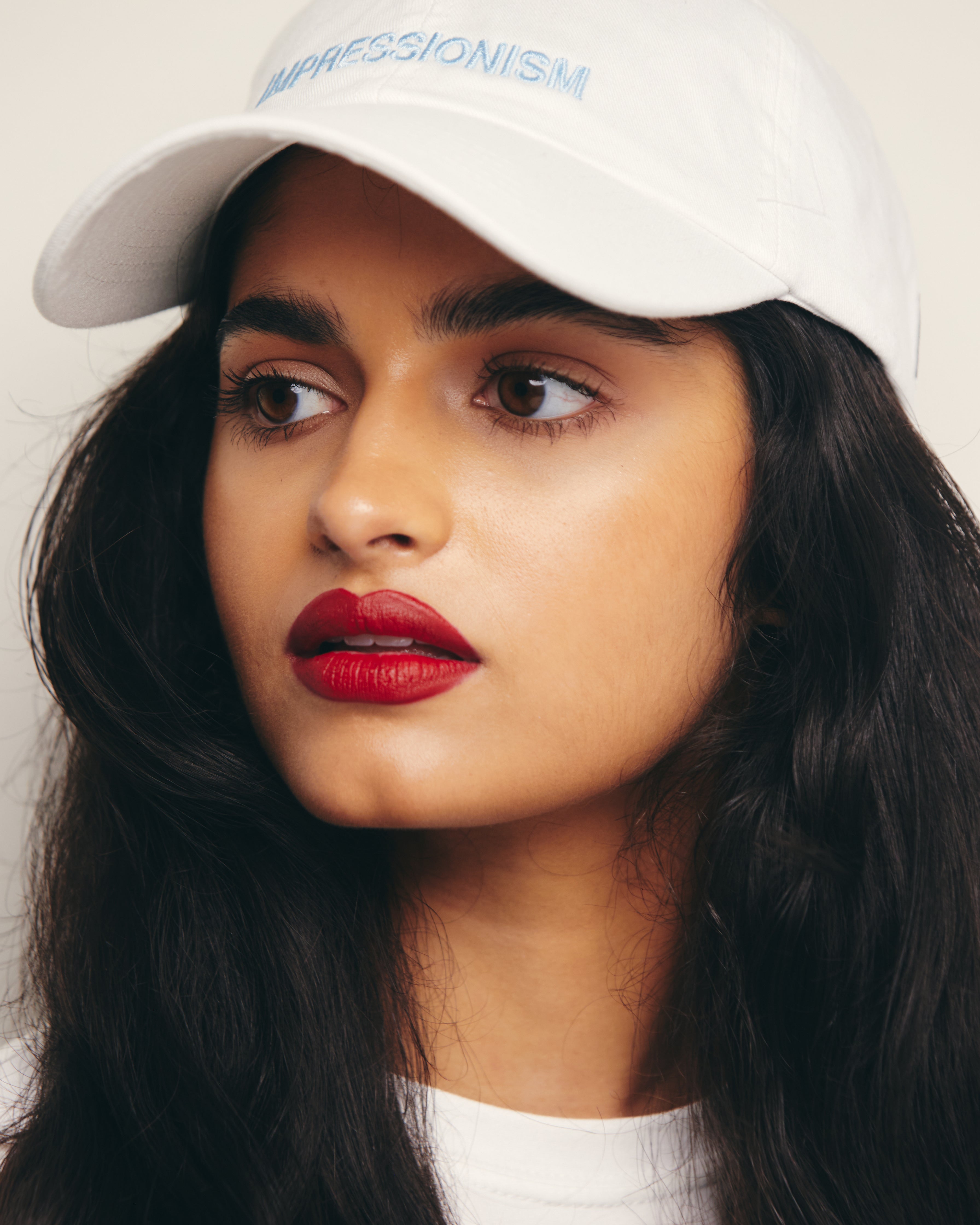 Mira Bhat wears White Baseball Cap / Dad Hat with Impressionism Art Movement Text Embroidery on Front. 100% Cotton.